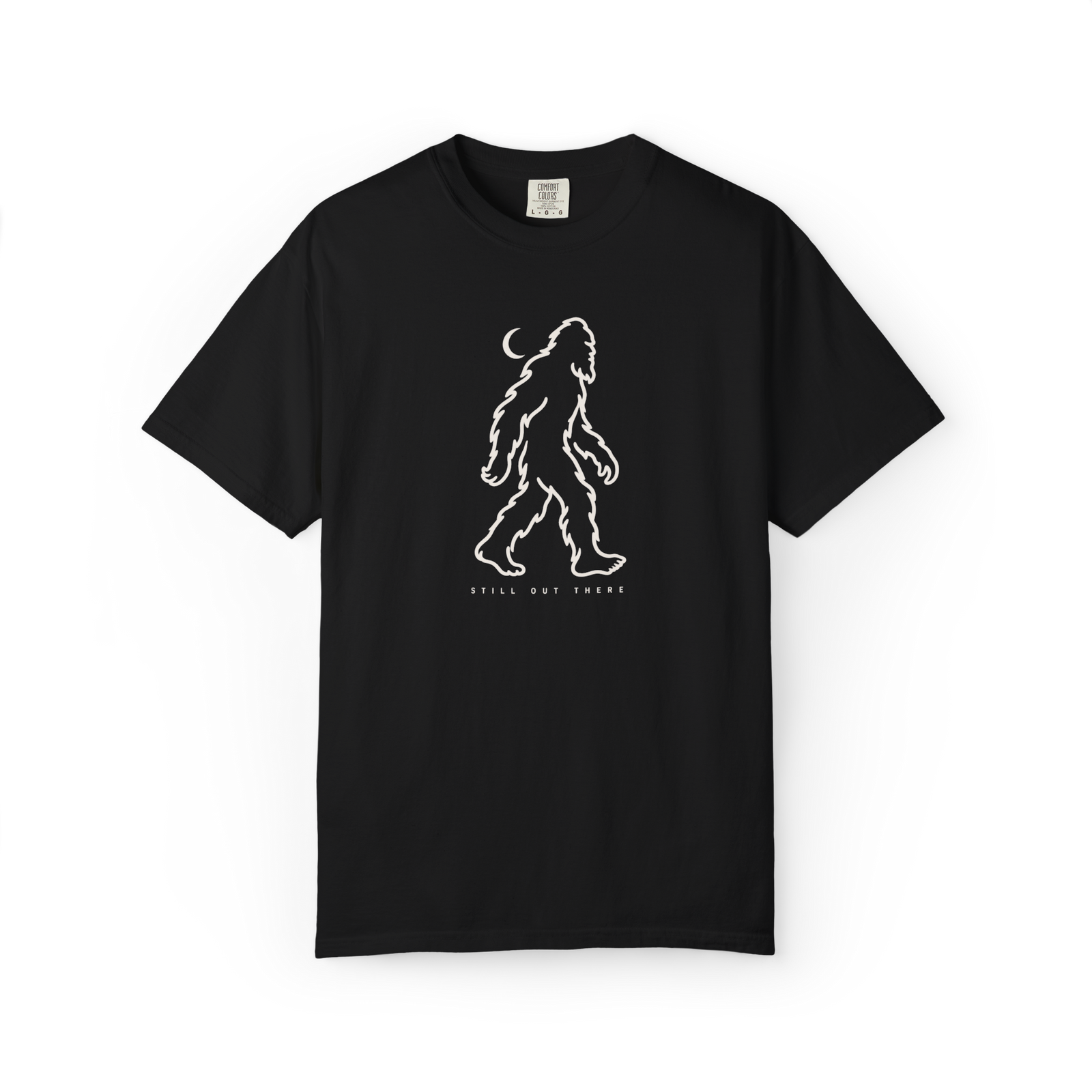 Black Bigfoot t shirt with white walking Sasquatch outline, crescent moon, and Still Out There text