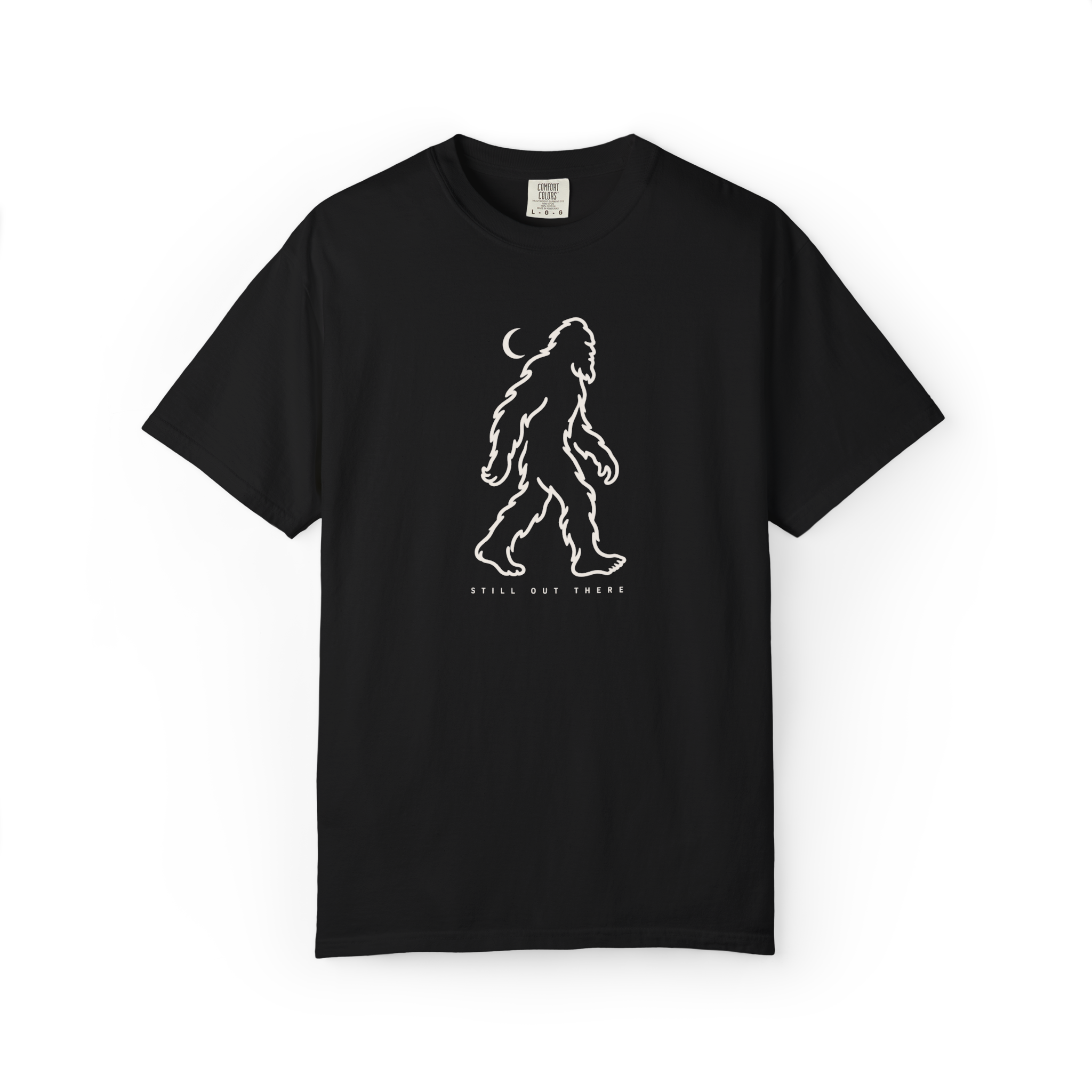 Black Bigfoot t shirt with white walking Sasquatch outline, crescent moon, and Still Out There text
