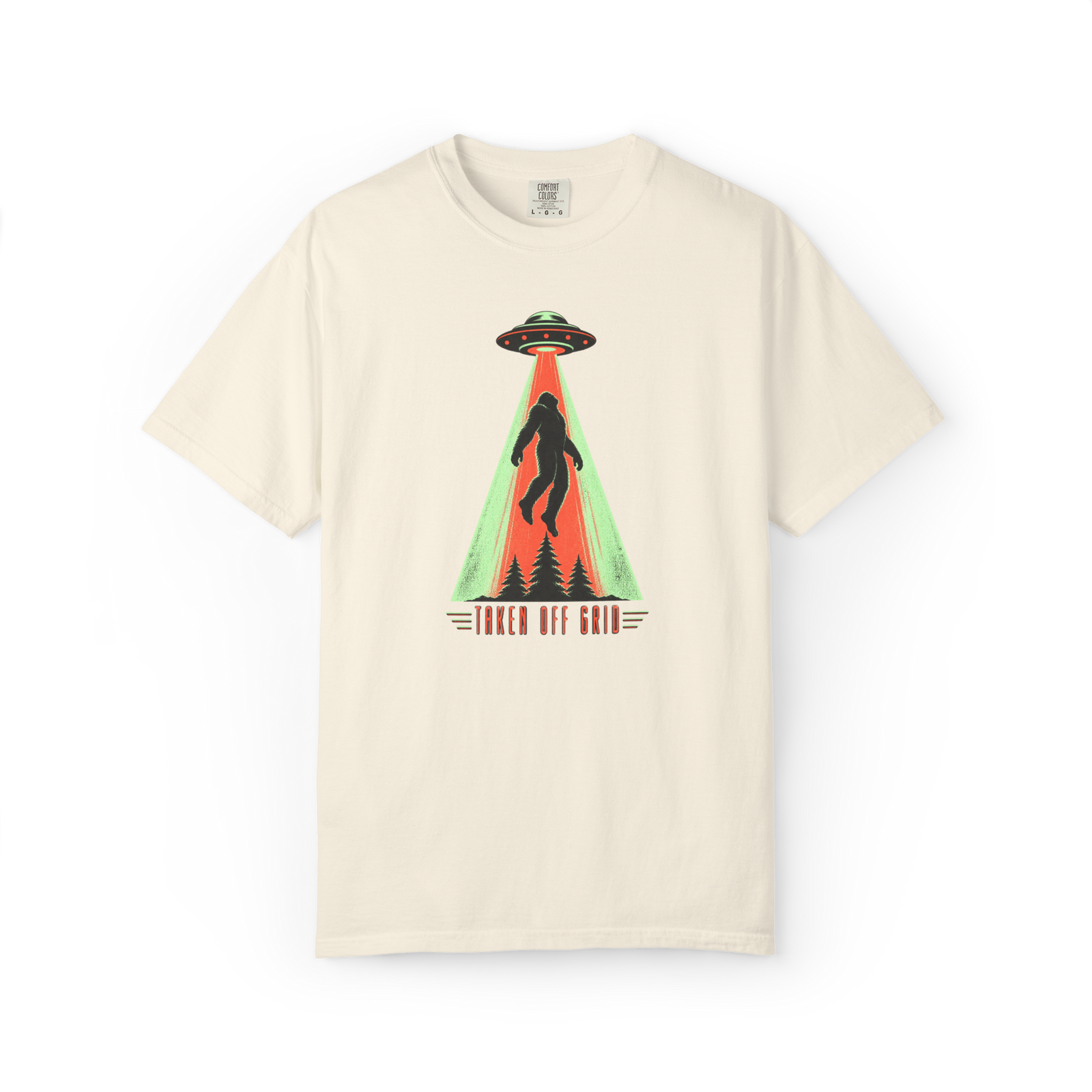 Taken Off Grid Bigfoot shirt featuring a Sasquatch being abducted by a UFO above pine trees with retro text on a cream tee