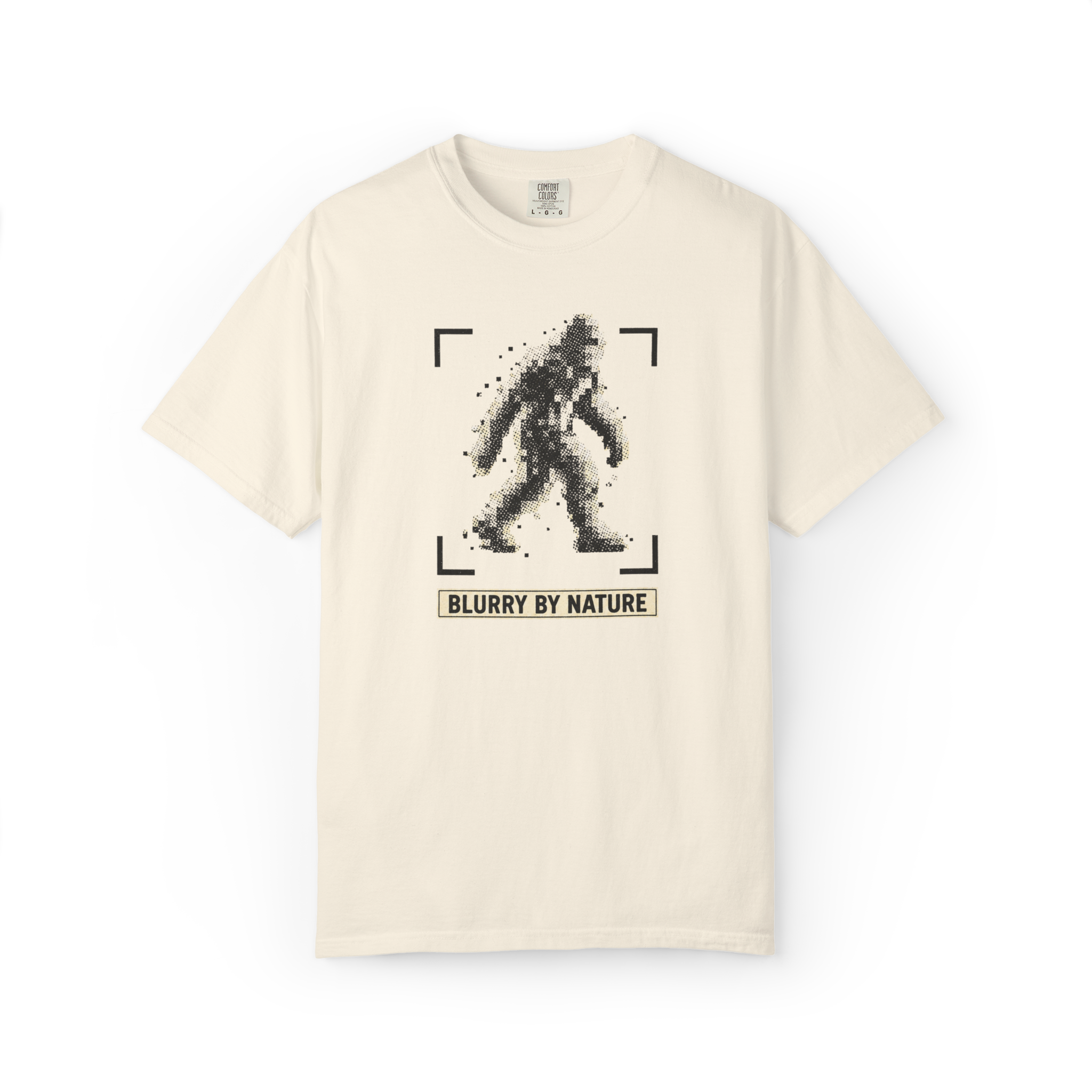 Ivory Bigfoot t shirt featuring a pixelated blurry Sasquatch inside camera focus brackets with Blurry By Nature text