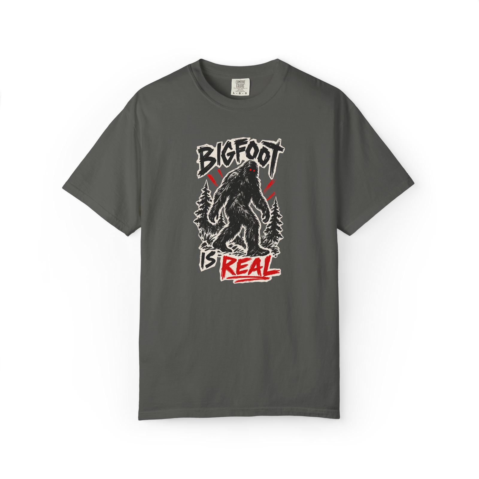 Bigfoot Is Real shirt with black Sasquatch graphic, forest trees, and red distressed text on a dark gray tee