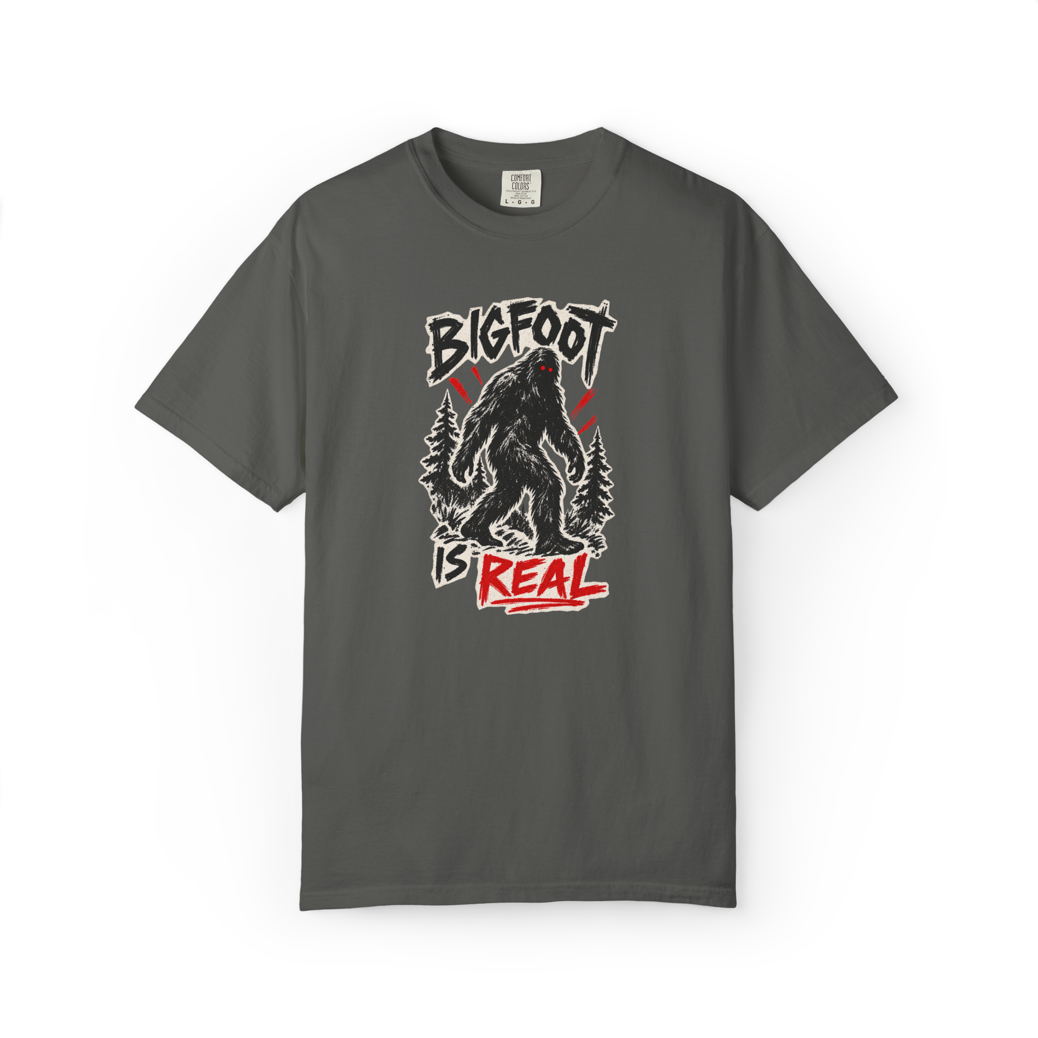 Bigfoot Is Real shirt with black Sasquatch graphic, forest trees, and red distressed text on a dark gray tee