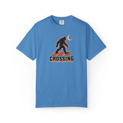 Blue Bigfoot t shirt with walking Sasquatch over a red crosswalk graphic, crescent moon, and Crossing text